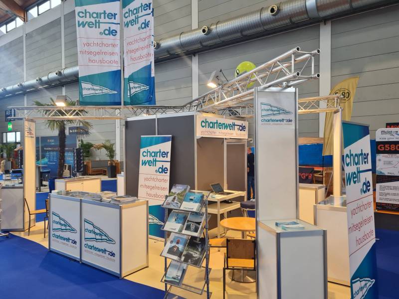 Messe Interboot in Friedrichshafen: Messestand der Charterwelt mit Tresen, Bannern und Katalogständern.