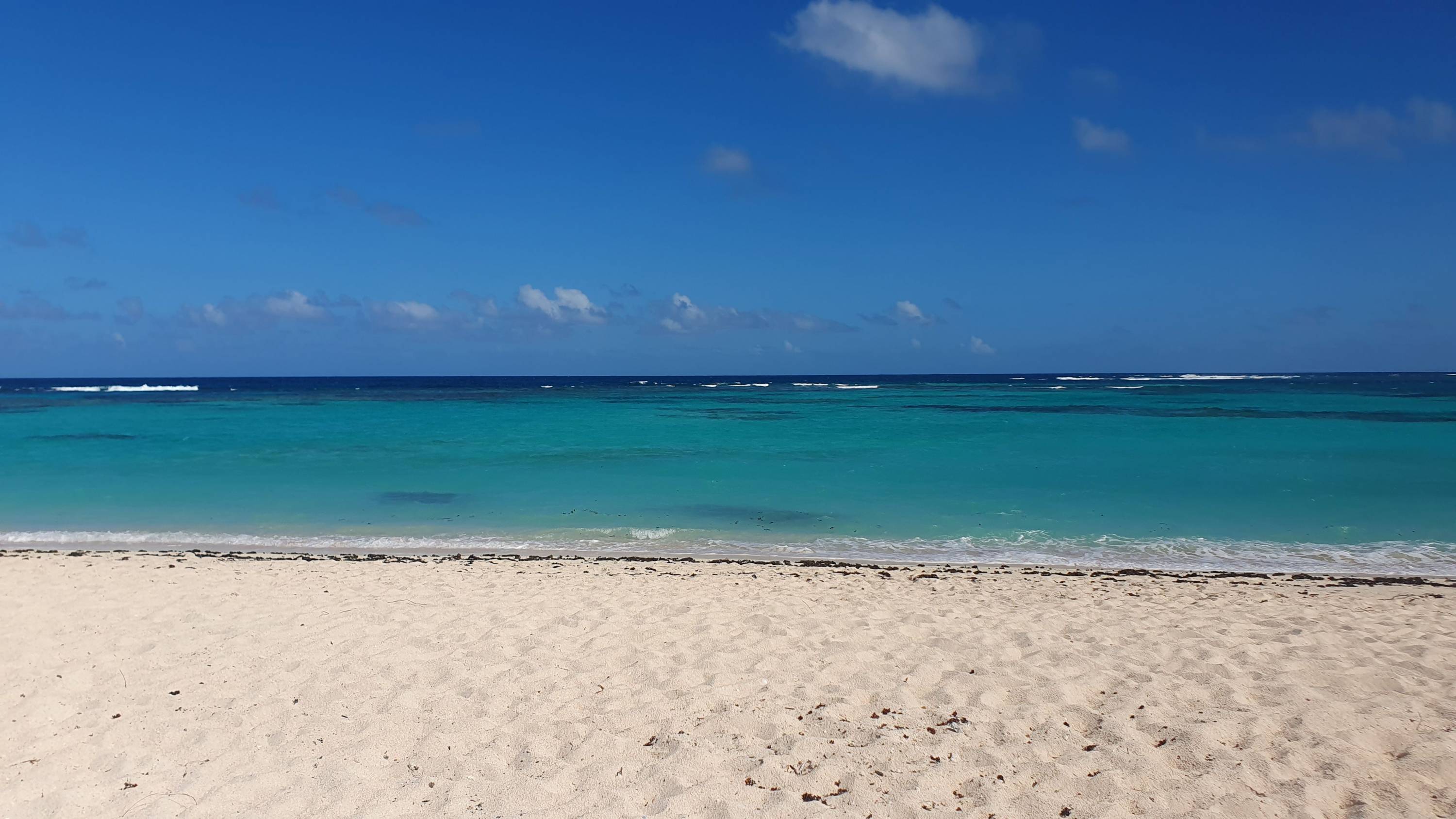 Weißer Sandstrand mit türkisblauem Wasser und weitem Blick aufs Meer auf Anegada, British Virgin Islands.