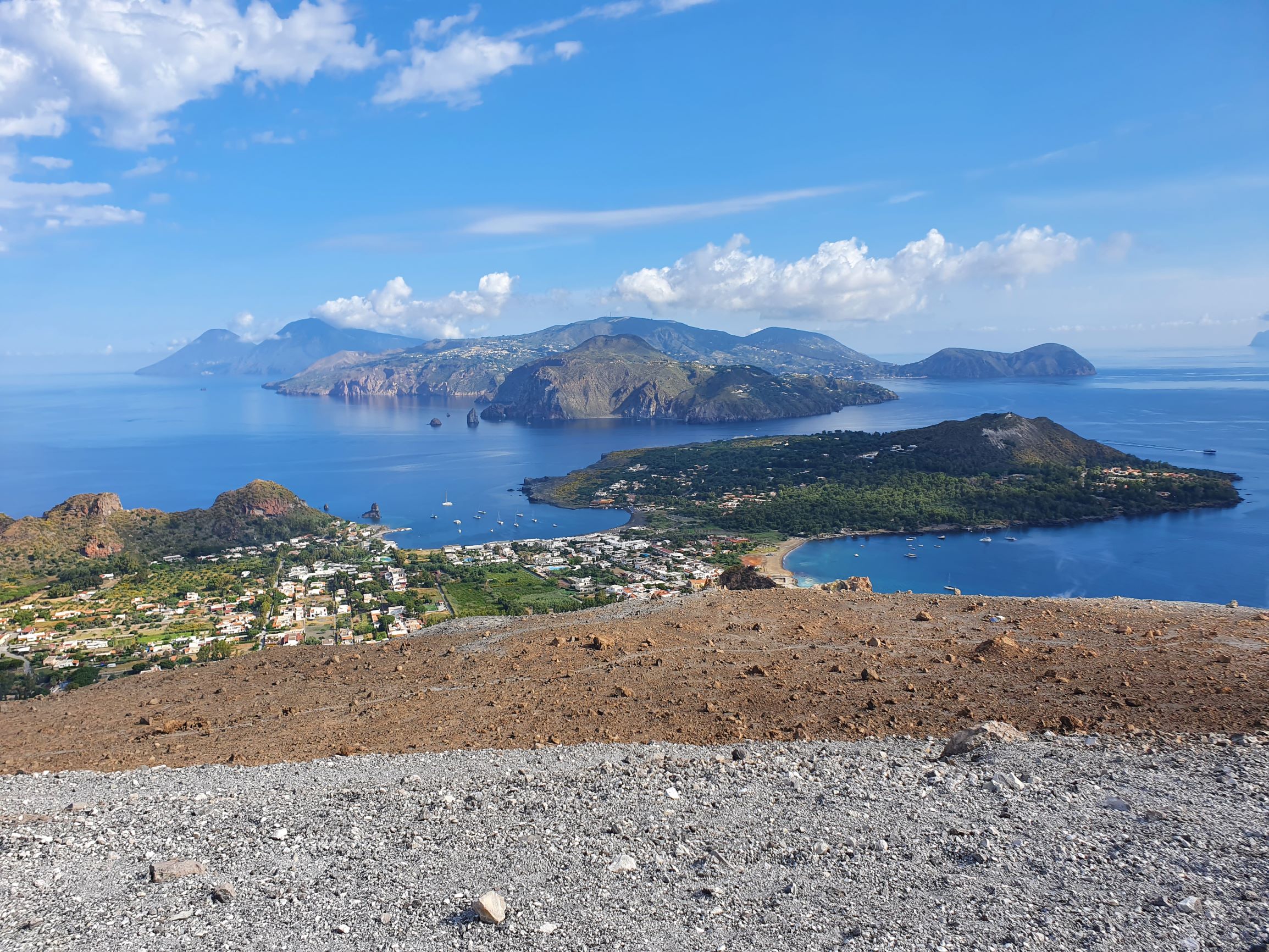 Ausblick von Gipfel des Vulcano über zwei Buchten. Der Vulkan ist noch aktiv. Stetig steigen schwefelhaltige Rauchwolken aus dem knisternden Gestein auf.