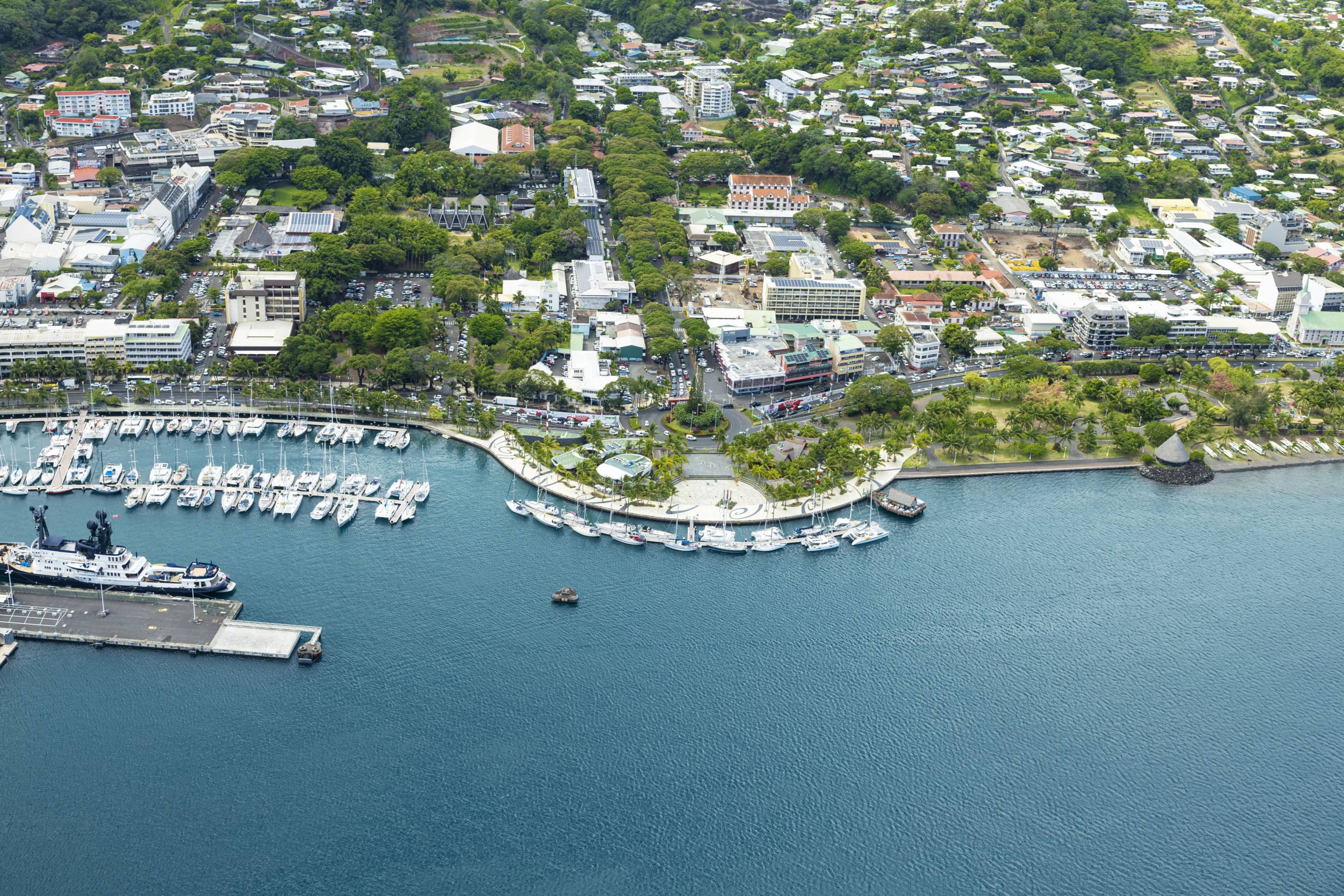 Luftaufnahme des Hafens und Stadtzentrums von Papeete auf Tahiti mit Yachthafen und Stadtbebauung.